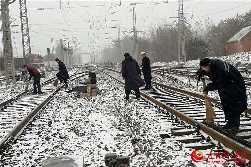 组织工作人员走上线路扫雪除冰。(郭松 摄)